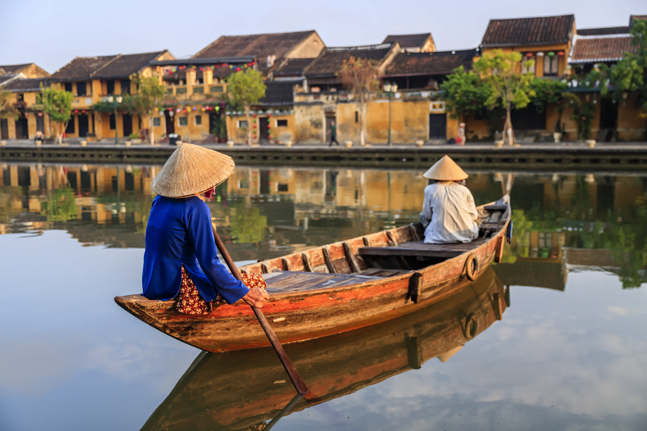 2 ladies rowing boat across the river